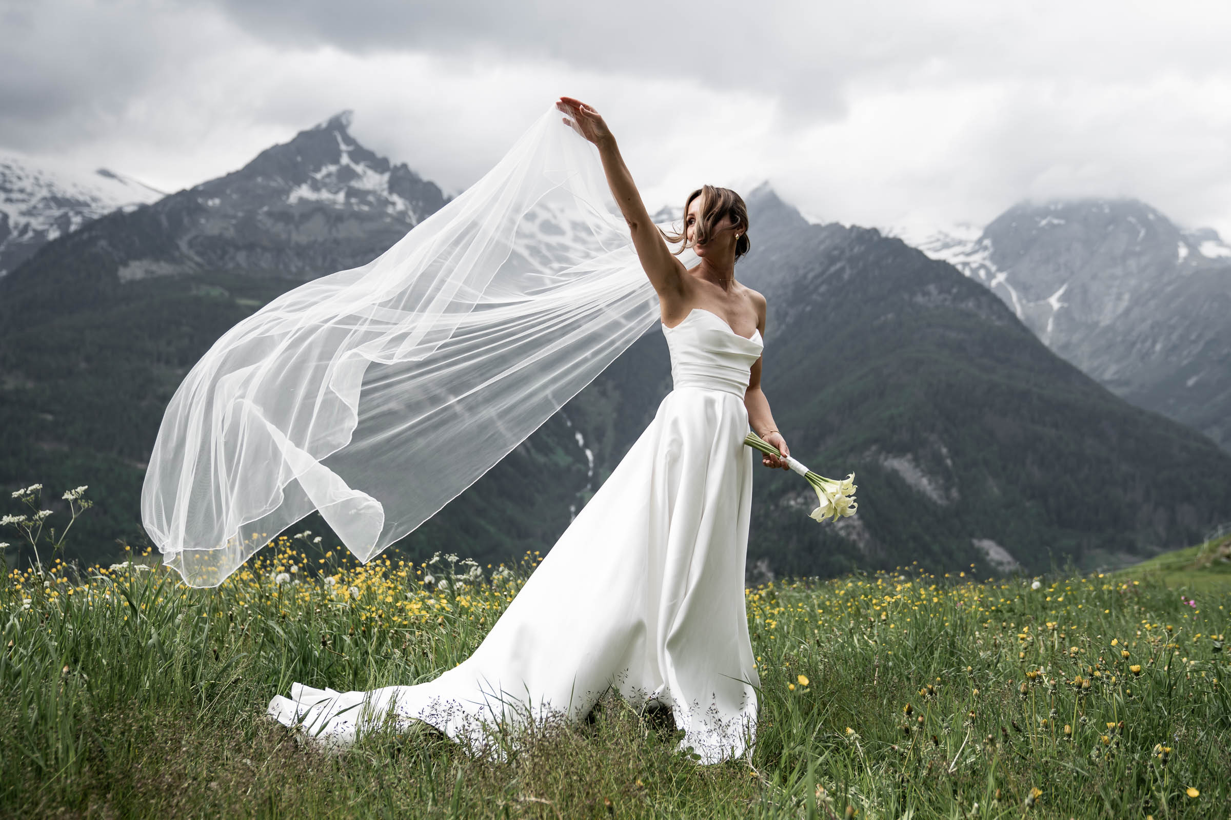Bride with veil flying against the Dolomites