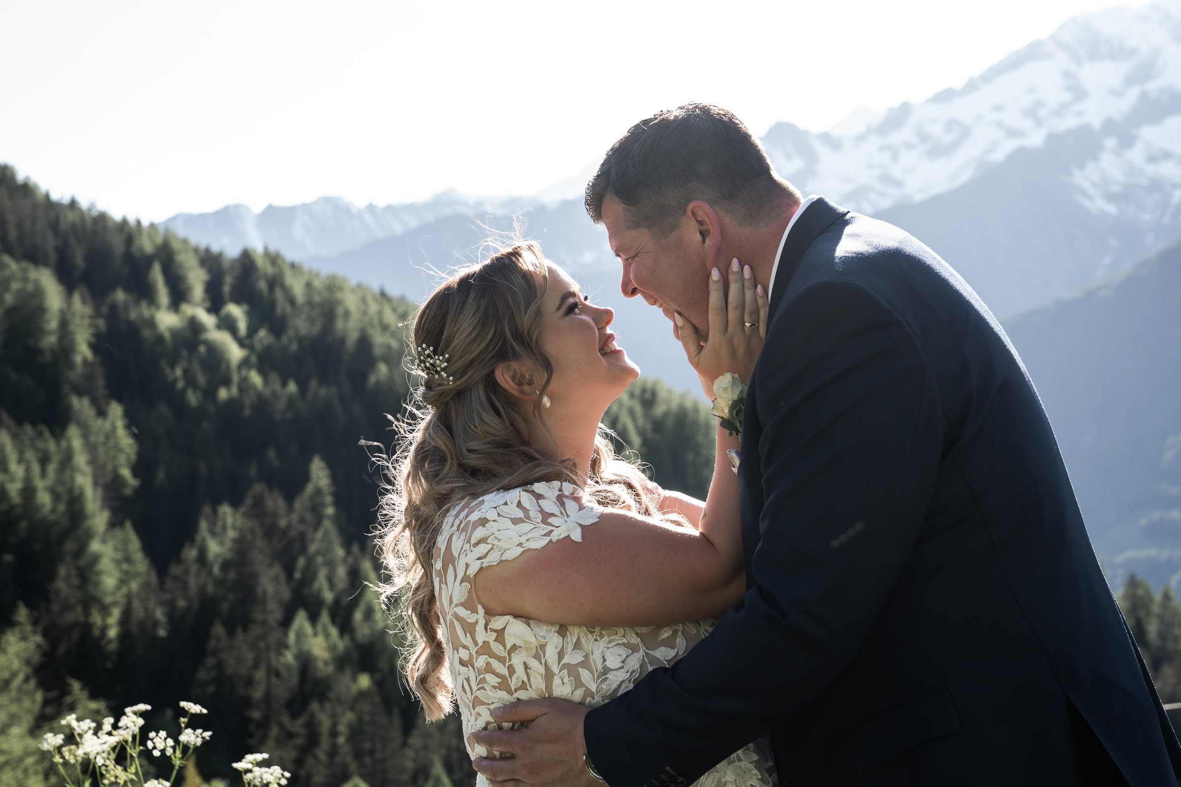 Bride and groom forehead-to-forehead, mountains beyond