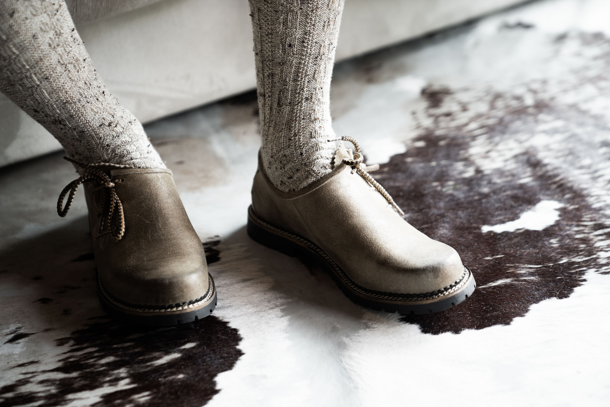 Tracht boots and ribbed socks on cowhide rug