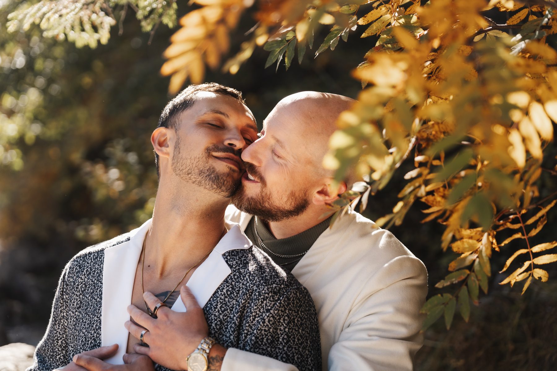 An embrace beneath orange rowan leaves