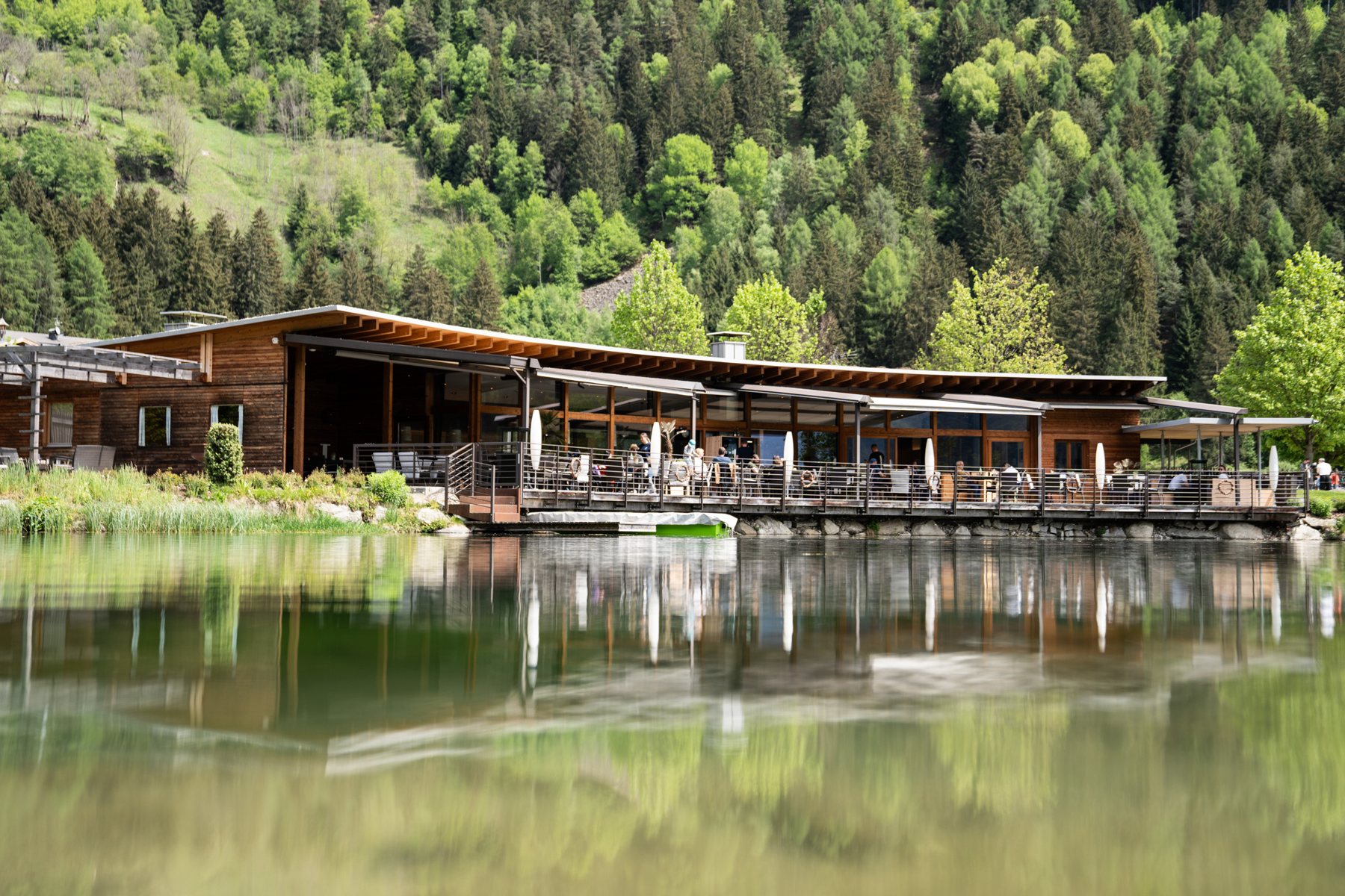 Thara SeeLounge by day, the wooden house with its terrace reflected in the lake